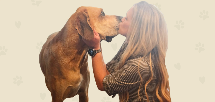 A woman kissing her dog on the nose